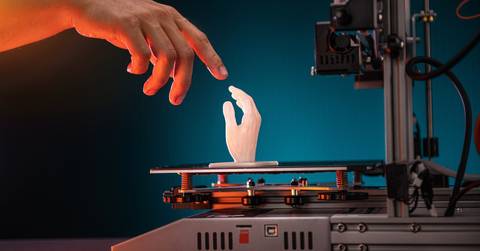 A human hand touching a 3D-printed hand