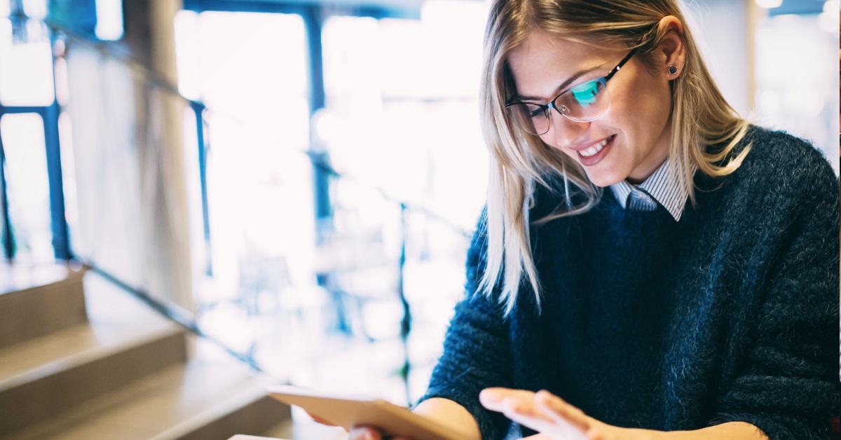 woman wearing glasses using tablet