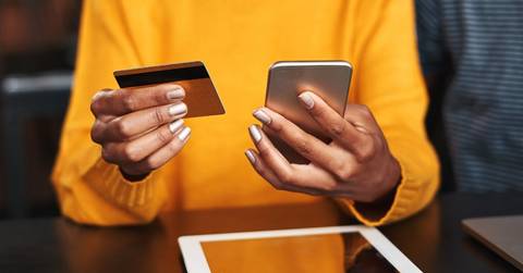 Woman research cash back vs. miles credit cards