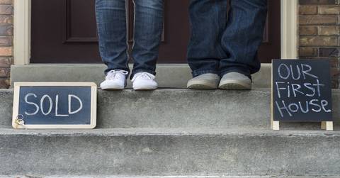 couple standing on stairs of new home