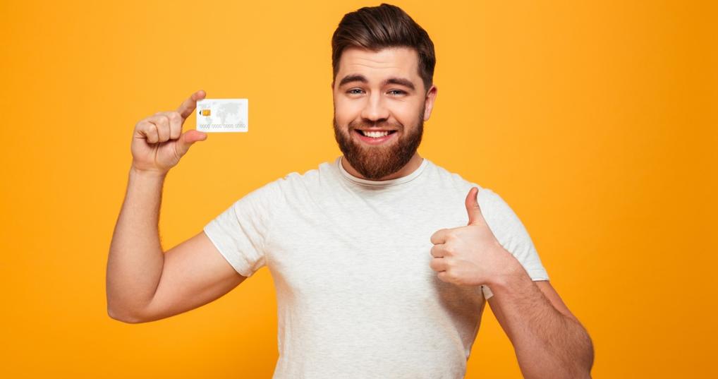 Smiling man holding credit card