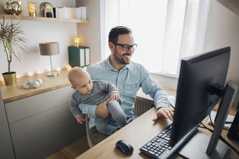 Dad working remotely with baby