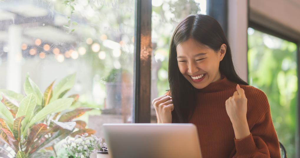 Excited woman using laptop