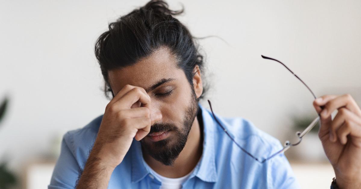Exhausted Young Arab Man Taking Off Glasses
