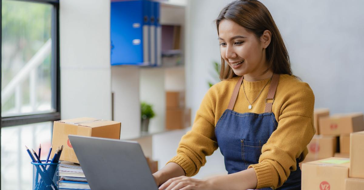 female entrepreneur uses a laptop computer to check online orders