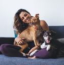 fit woman having fun with adorable mongrel dogs