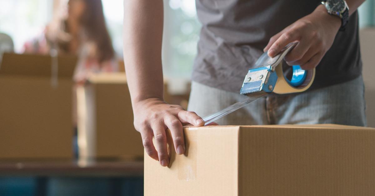 hand of man use tape sealing cardboard box
