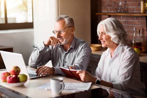 Happy couple looking at laptop