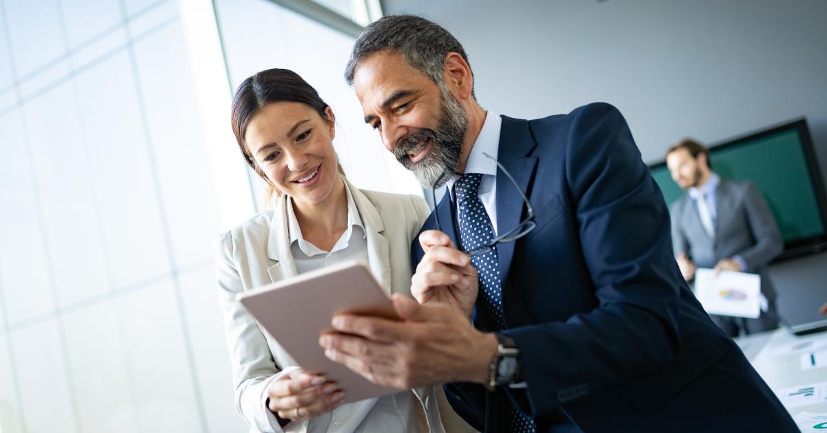 happy business colleagues in modern office using tablet
