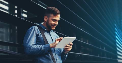 Man using a tablet computer outside