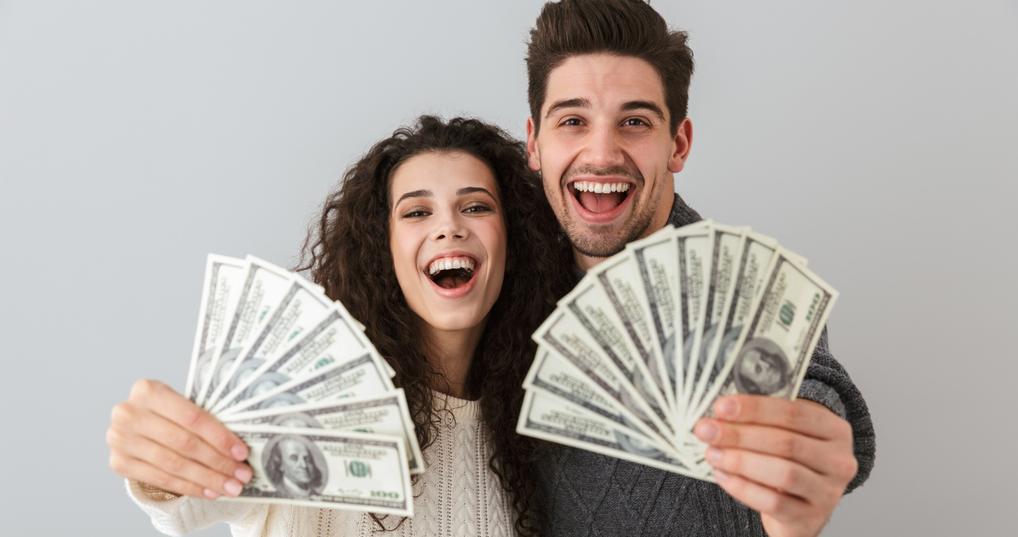 Enthusiastic couple holding money