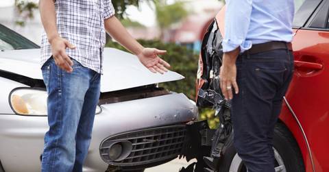 Two men talk after a minor car accident