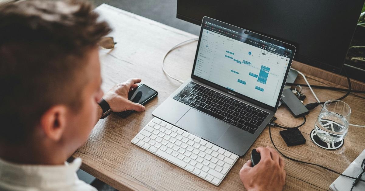 man using mouse on macbook pro