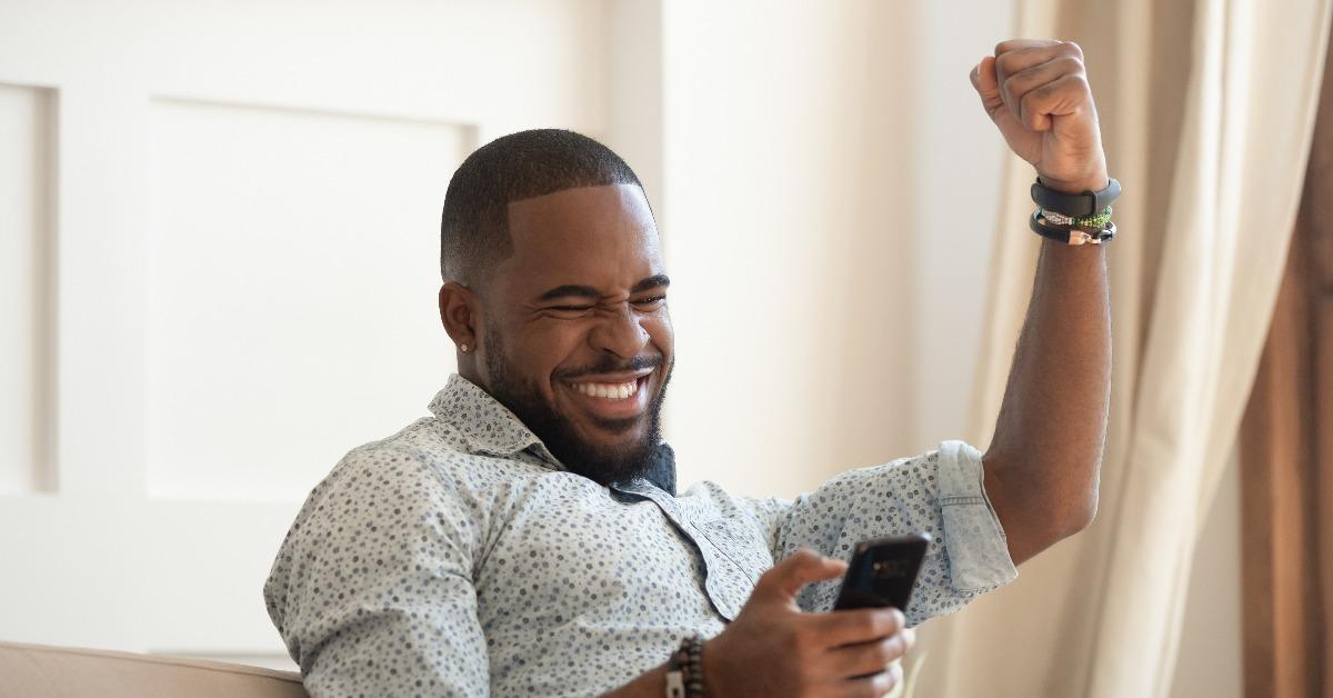 overjoyed black man holding smartphone