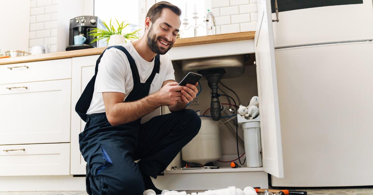 plumber using mobile phone on work