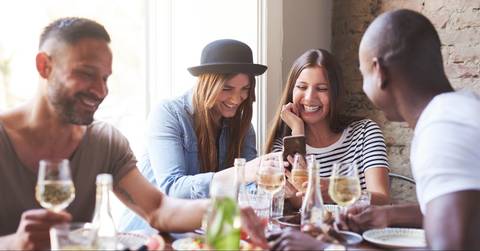Friends paying each other back at a restaurant