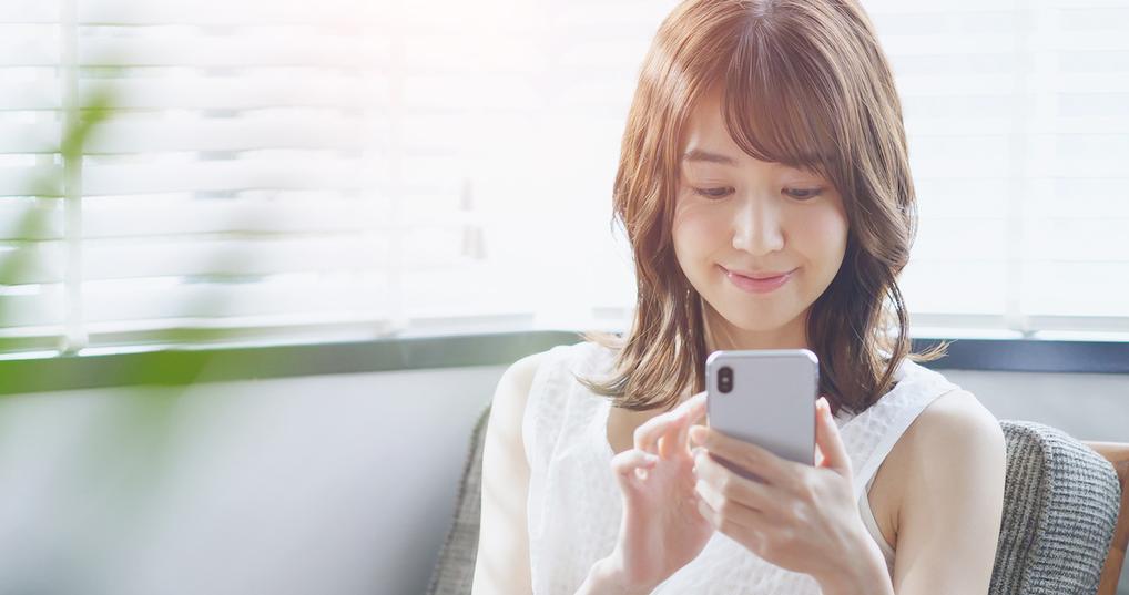 Smiling woman using smartphone