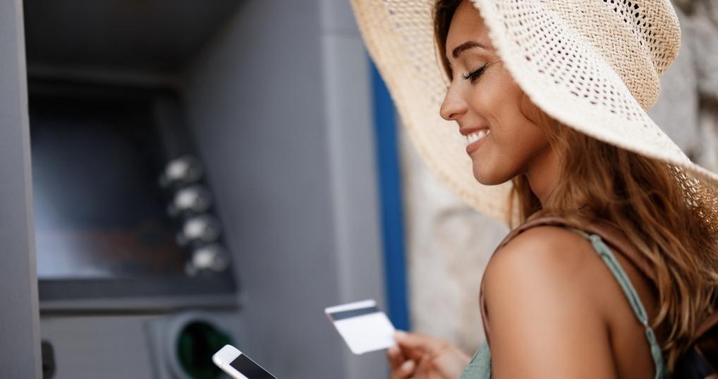 smiling woman standing in front of an ATM