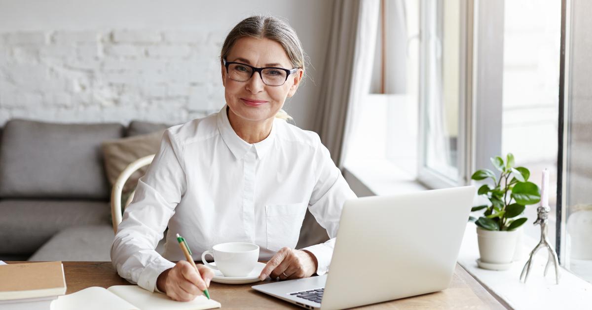 talented mature woman writer sitting in front of laptop