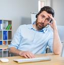 tired man working at a computer
