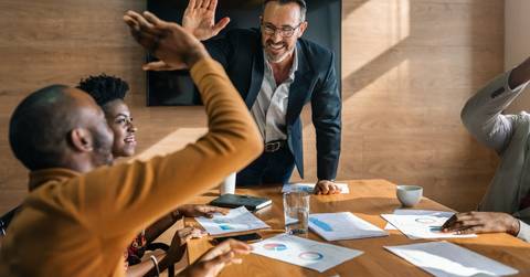 two men high-fiving during a meeting