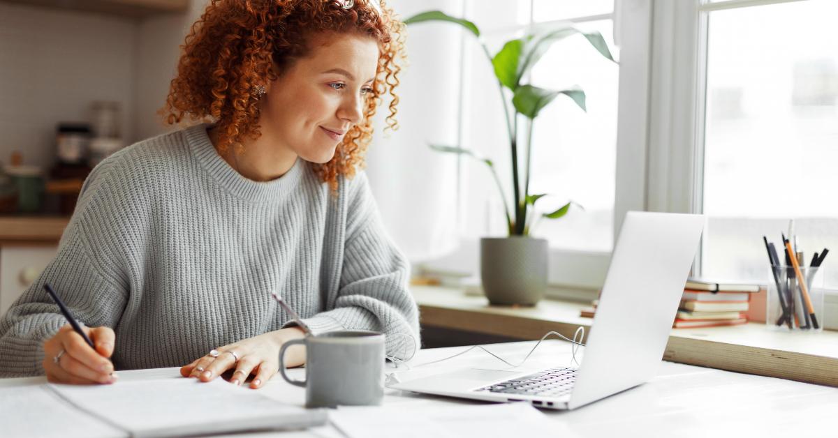 university student with curly red hair doing homework 