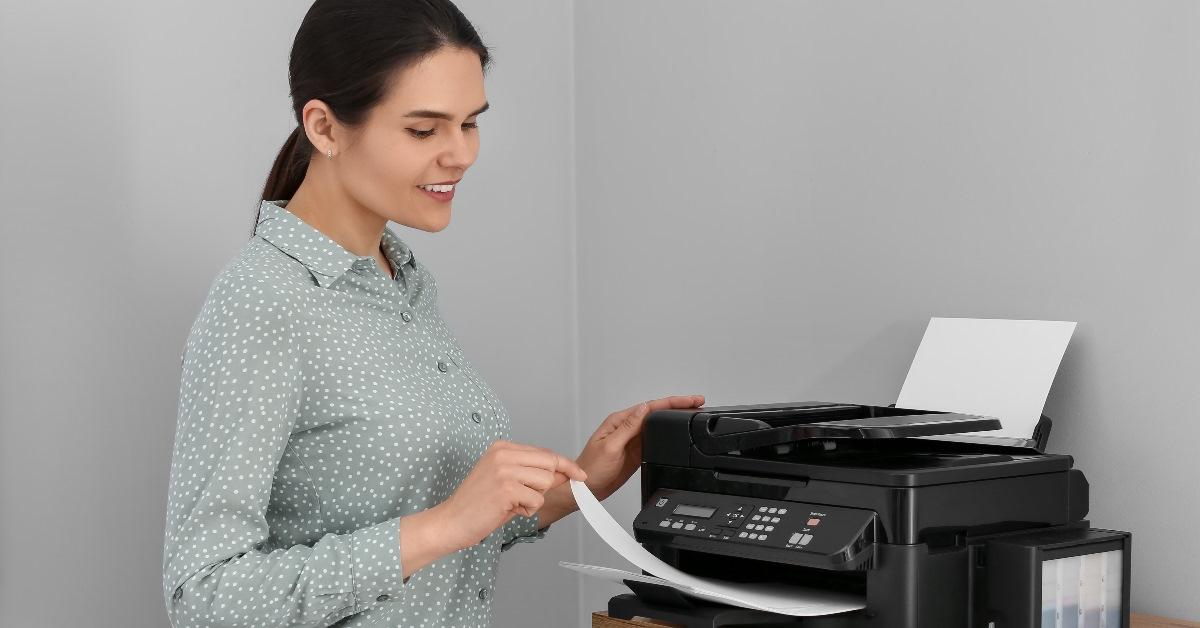Woman printing papers at home.