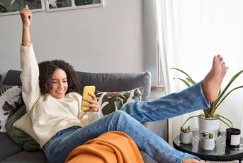 woman relaxing on couch using phone 