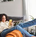 woman relaxing on couch using phone 