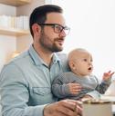 Young father working from home and babysitting his baby boy in the same time.