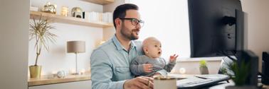 Young father working from home and babysitting his baby boy in the same time.