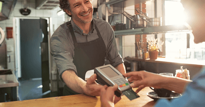 A customer inserts their credit card into a credit card reader.