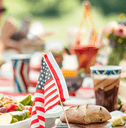A group of friends sit at a picnic table to celebrate the Fourth of July.