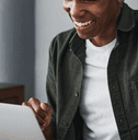 Man smiles while using his laptop. 