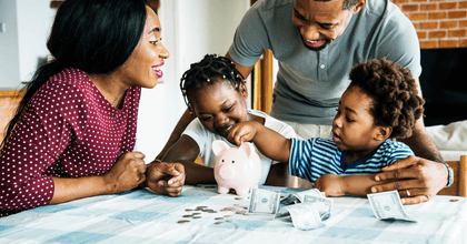A family gathers at the table, counting money from a piggy bank.