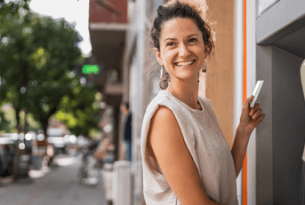 Smiling woman using an ATM