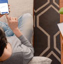 A woman uses a financing app while sitting on her couch.